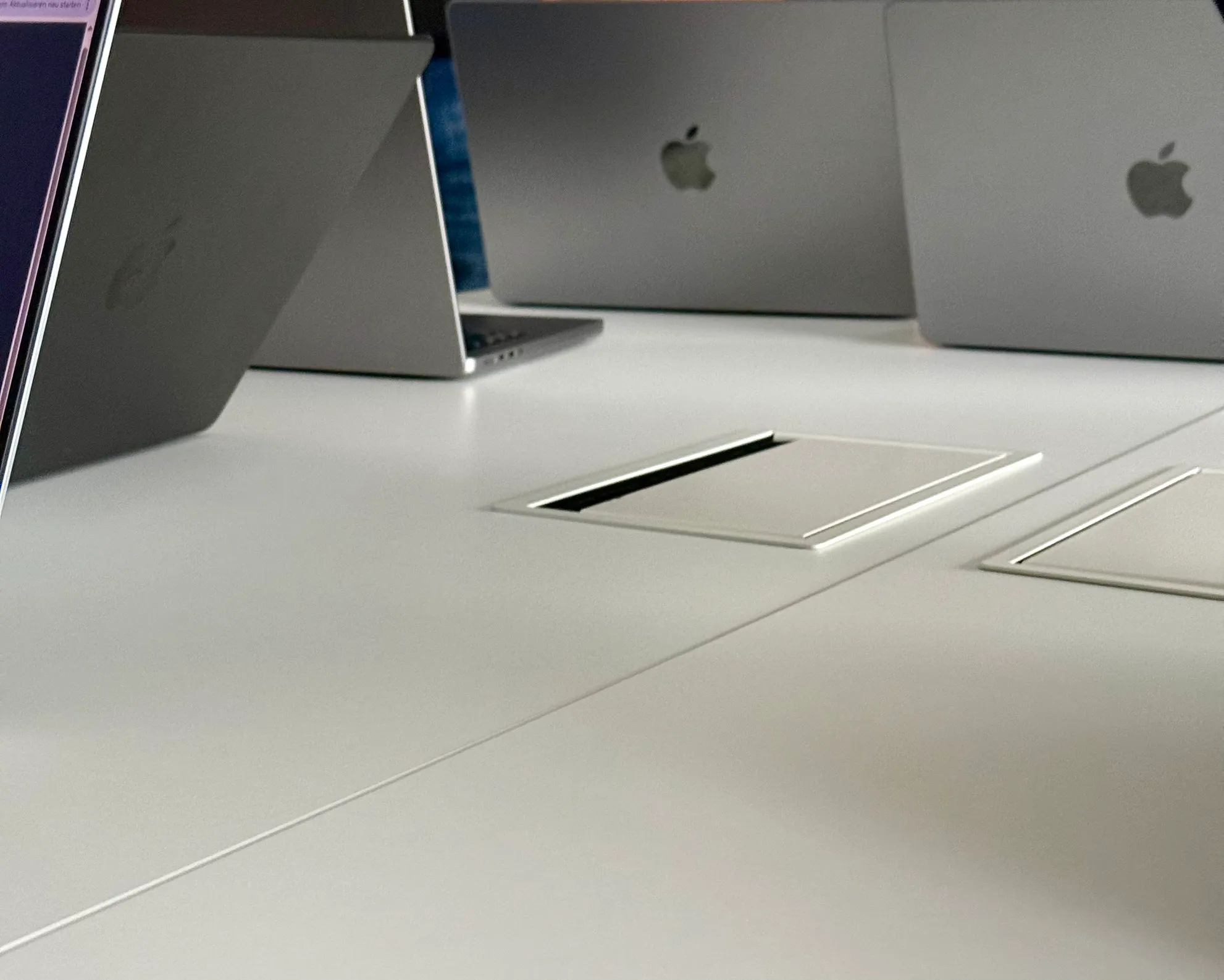 a table with four macbook backs visible